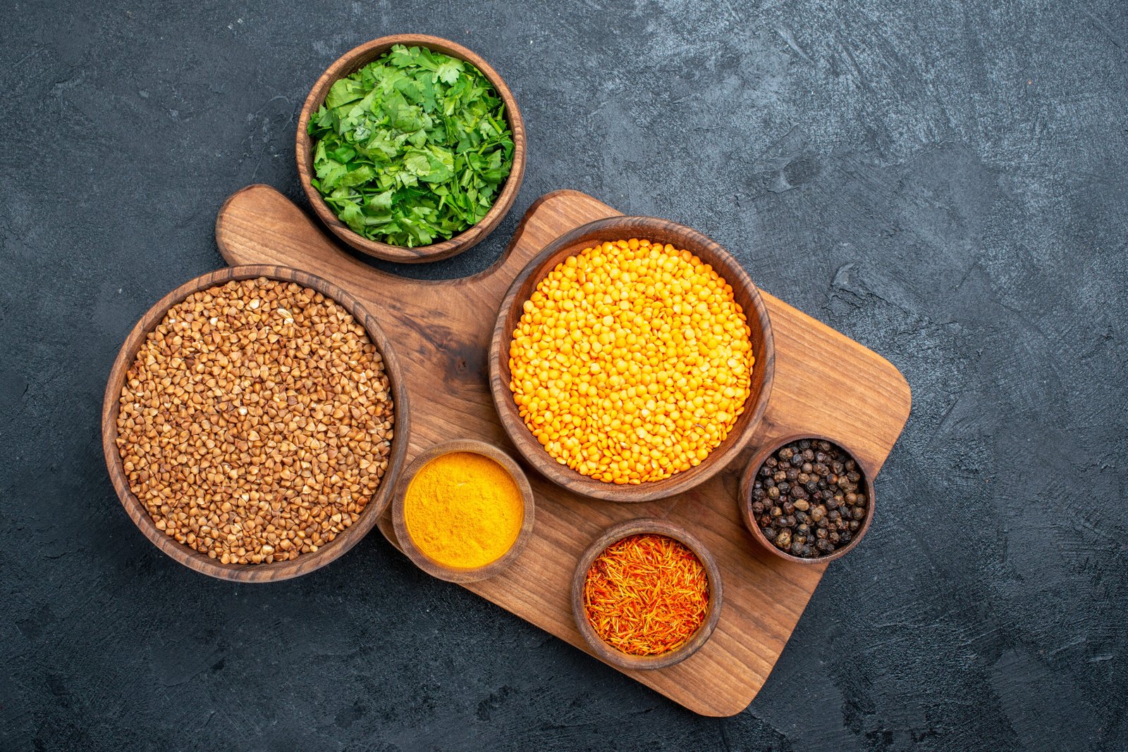top-view-raw-buckwheat-with-seasonings-greens-dark-grey-space